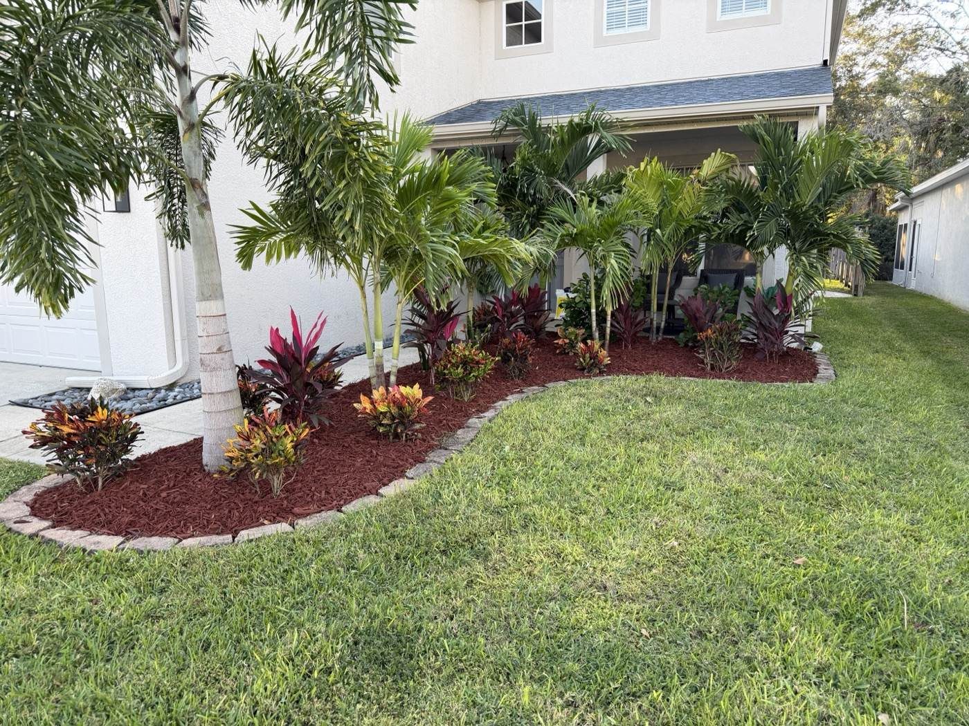 A Florida landscape bed with long-blooming flowering plants in full sun in New Port Richey, FL